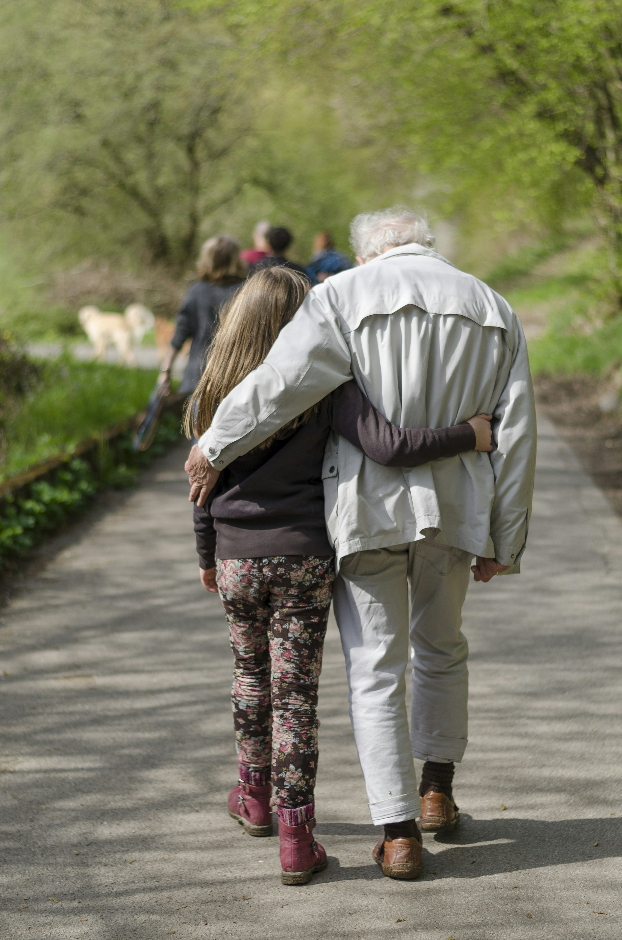 Avô caminhando com a neta, representando legado entre gerações